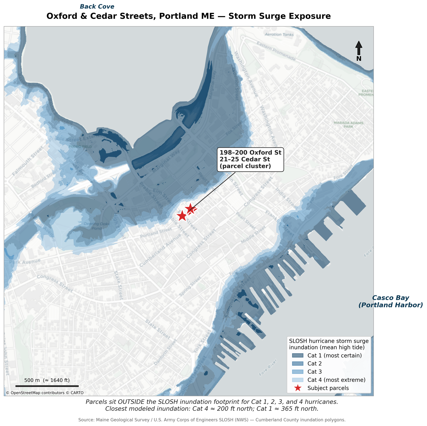 Map of Portland, Maine showing SLOSH hurricane storm-surge inundation categories 1 through 4 shaded in blue around Casco Bay and Back Cove. The four subject parcels at the corner of Oxford and Cedar streets sit outside every category and are marked with red stars.