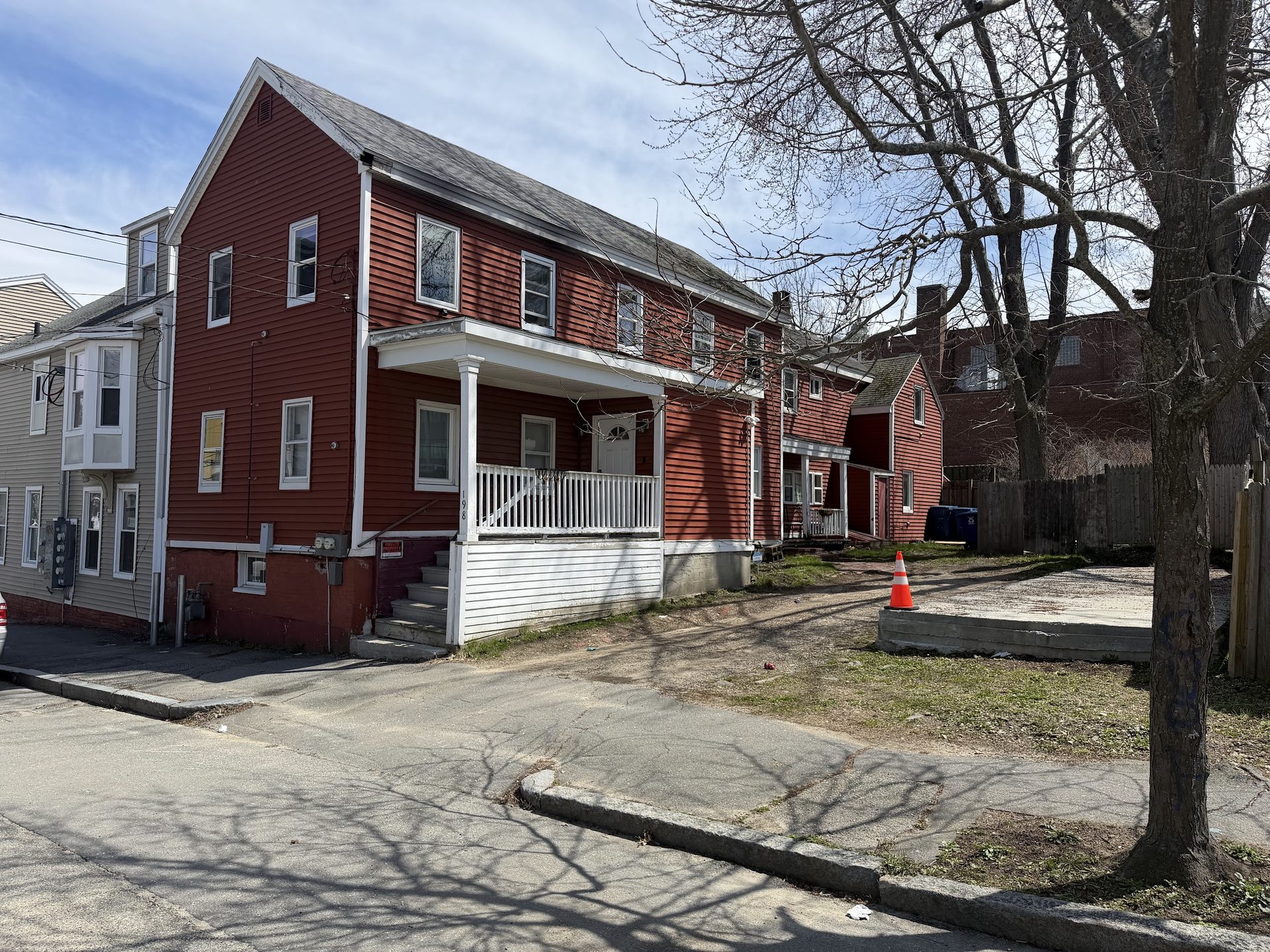 Street-level view of 198 Oxford — red-sided two-unit with open porch.