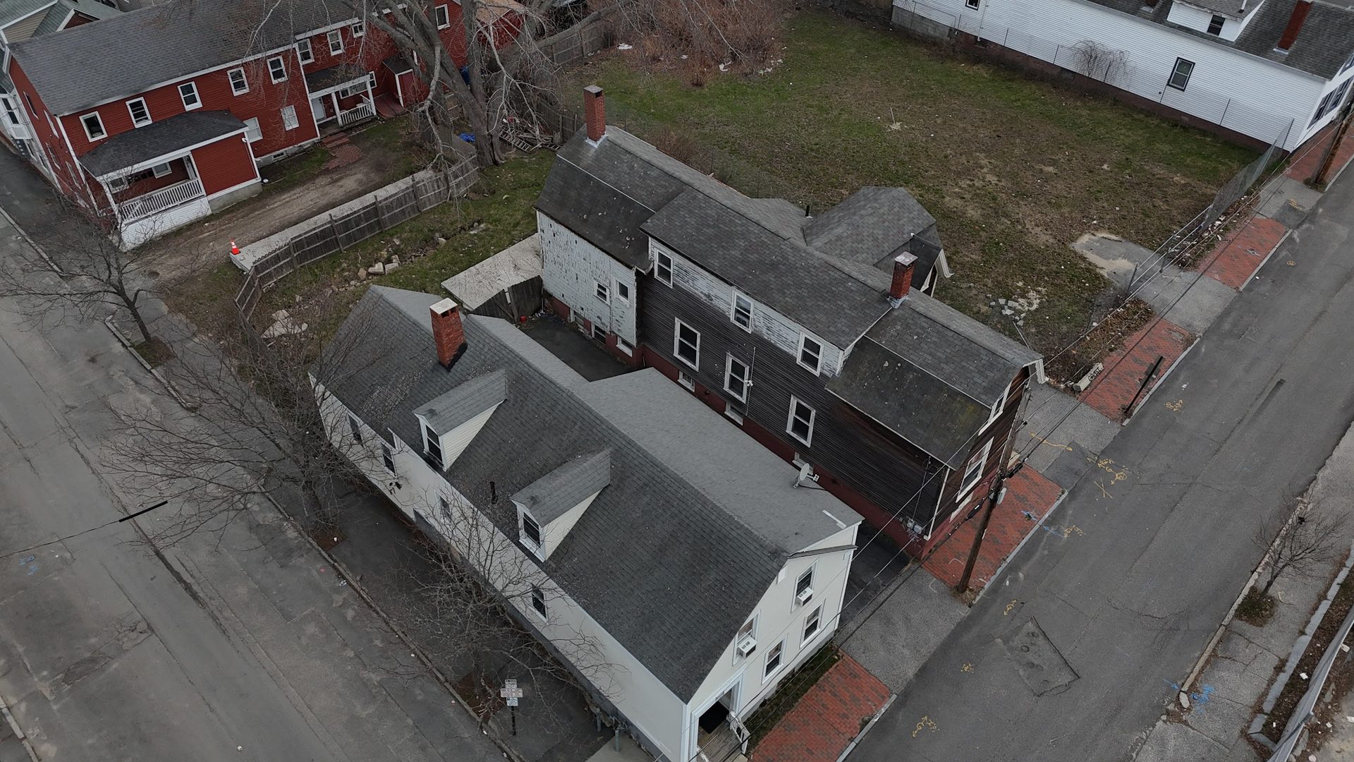 Aerial view of the four-parcel assemblage at Oxford and Cedar — three buildings and one vacant lot form an L at the corner.